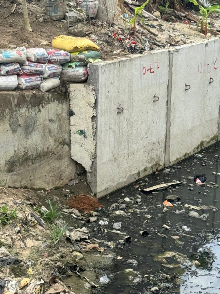 Critical blockage at culvert opening demonstrating abnormal structural loading conditions. Waste mass exerts unaccounted lateral pressure on concrete abutments and vertical surcharge on the invert slab. The complete obstruction of flow path creates hydrostatic pressure differentials not considered in original design.